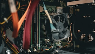 A close up of a computer with a fan and wires