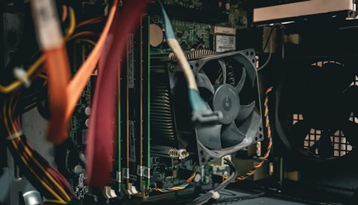 A close up of a computer with a fan and wires