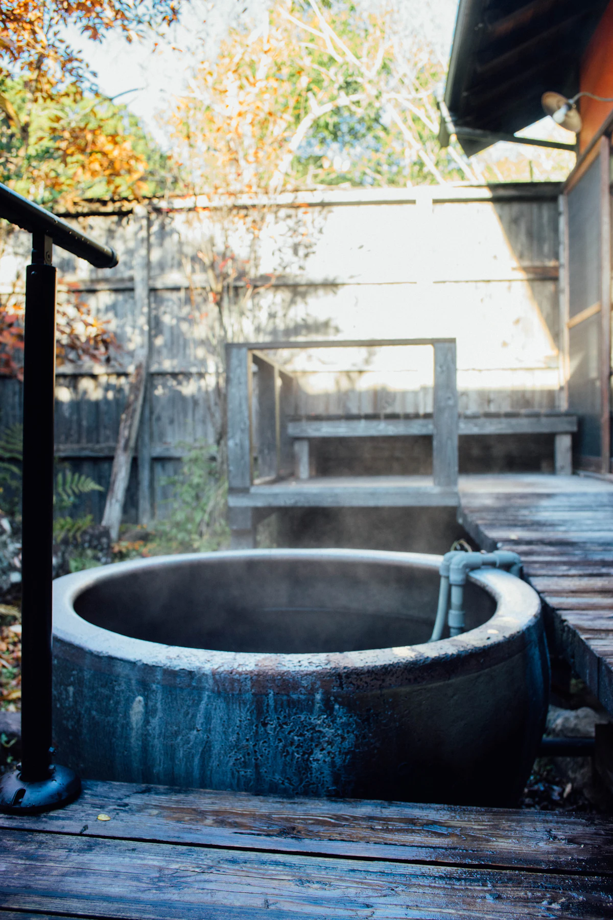 A traditional outdoor wooden onsen tub on a deck at a Japanese ryokan in Kumamoto
