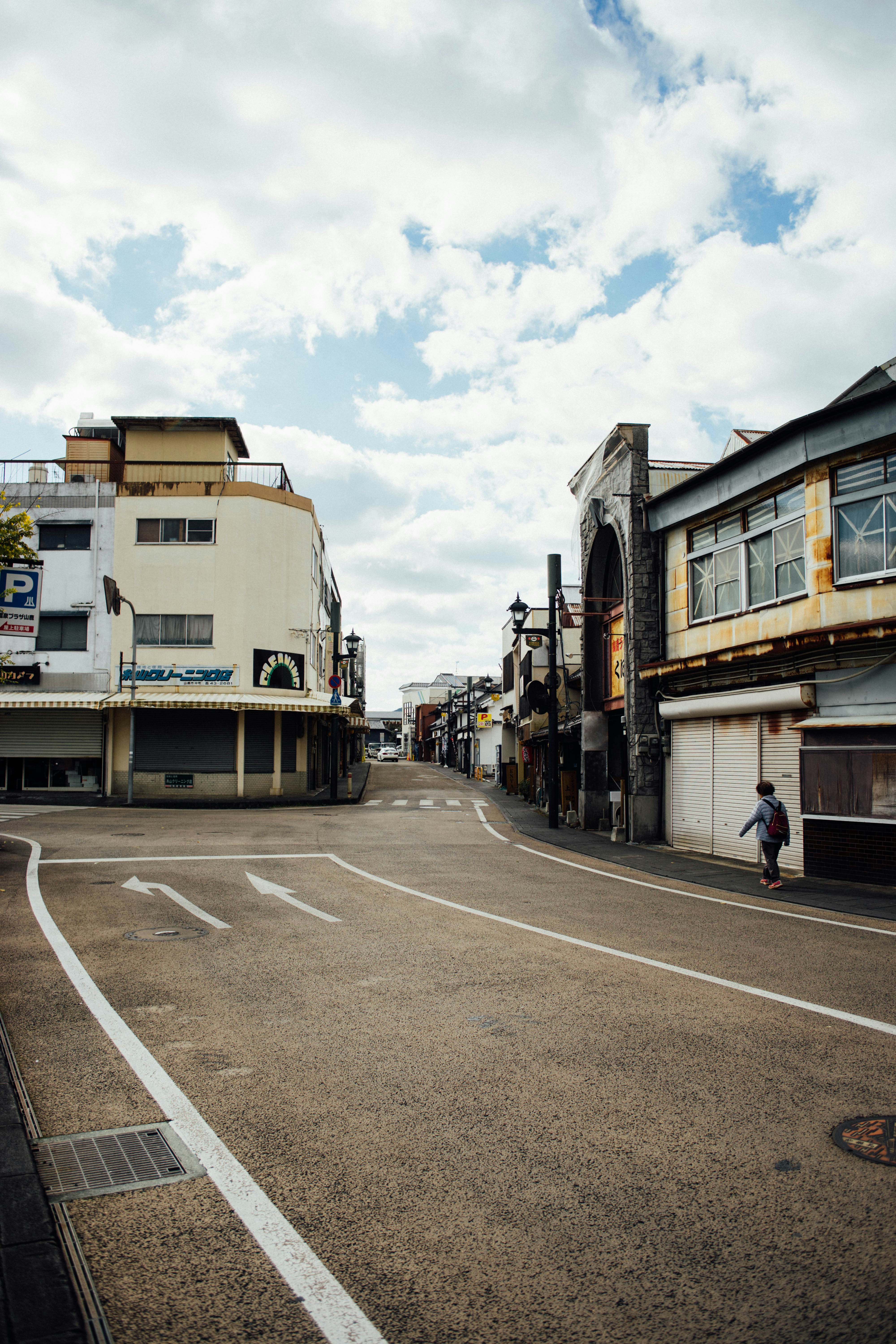A man riding a skateboard down a street next to tall buildings