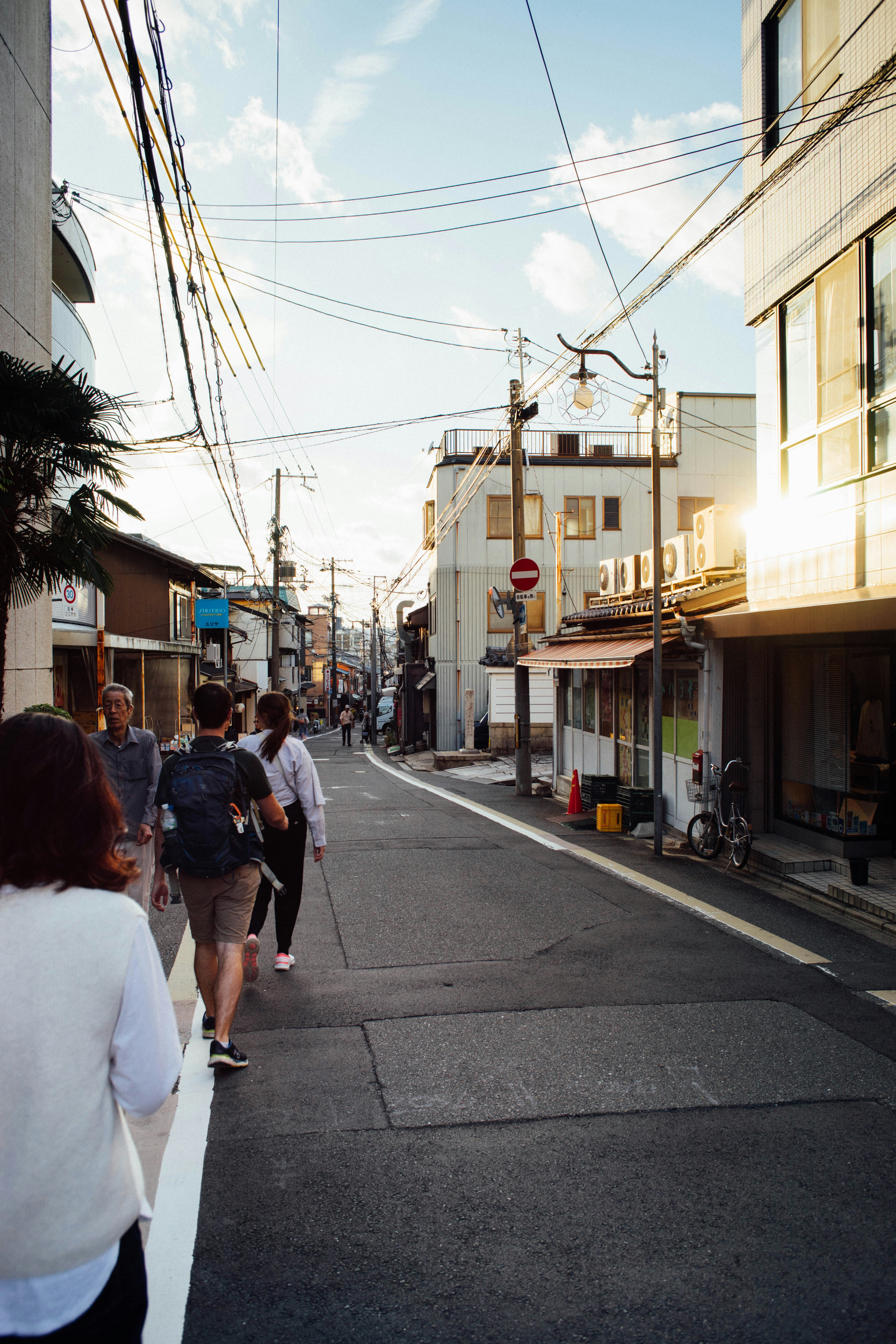 A group of people walking down a street next to tall buildings