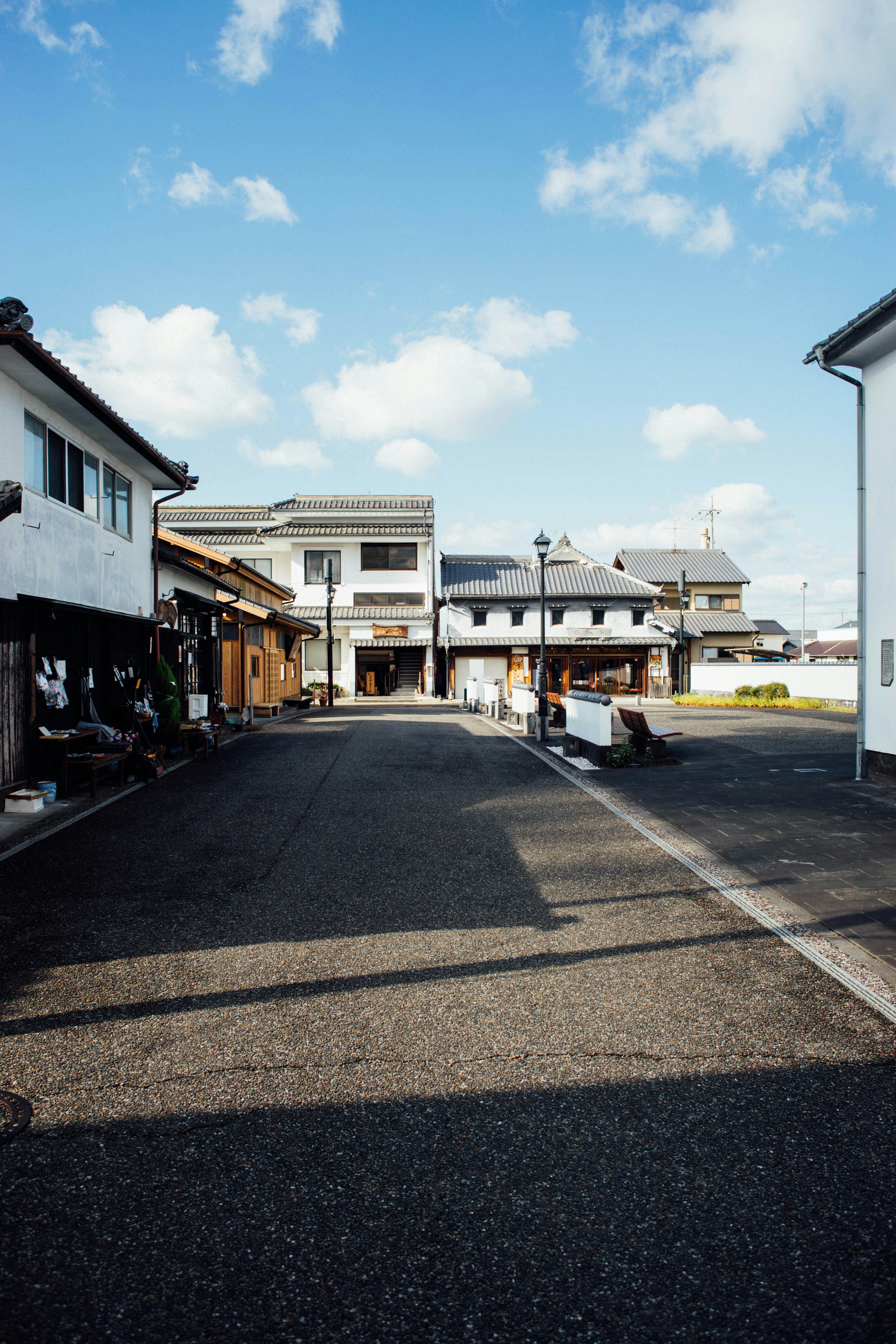 An empty street with a few houses in the background