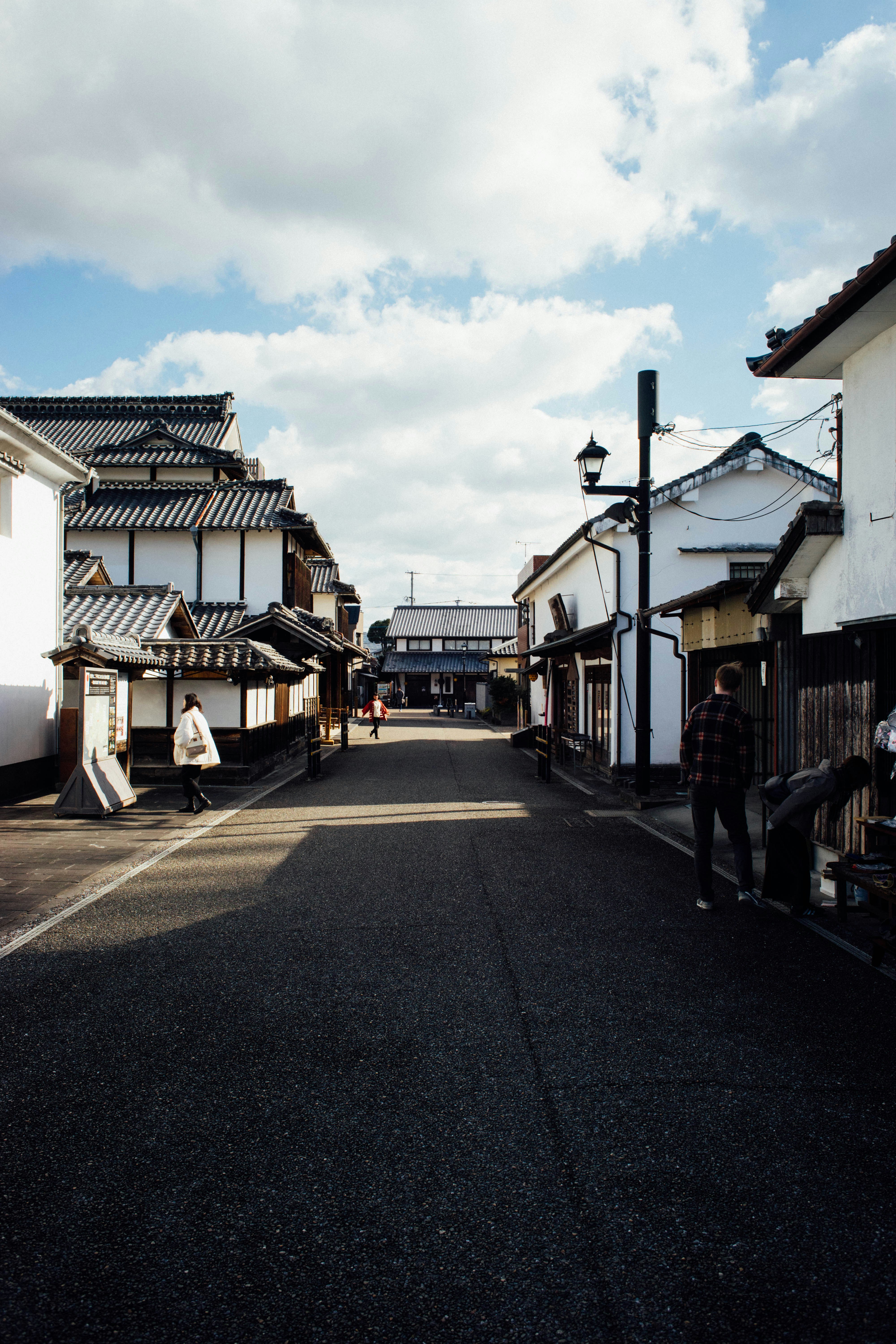 A street lined with white buildings under a cloudy sky