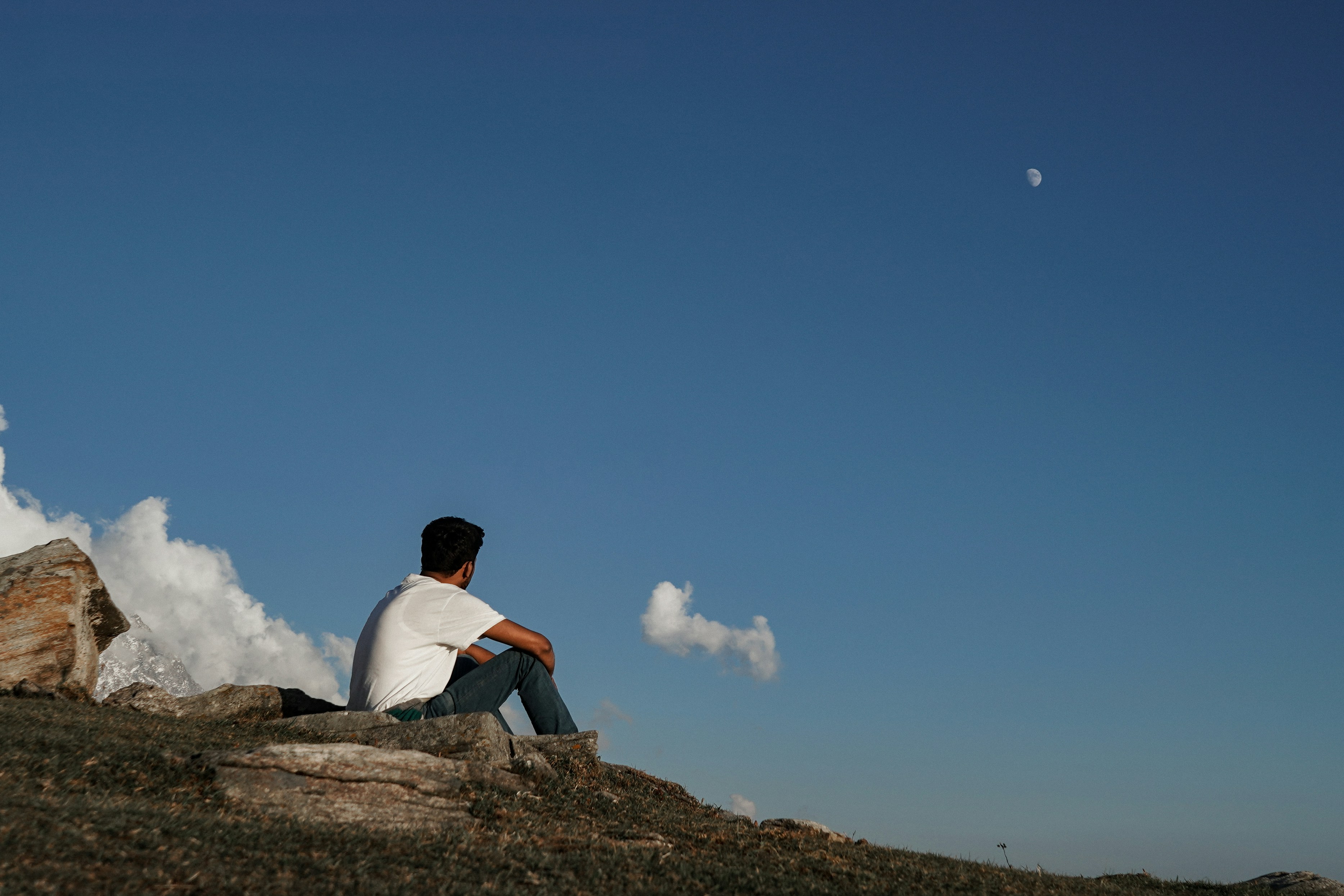 A man sitting on top of a rocky hill