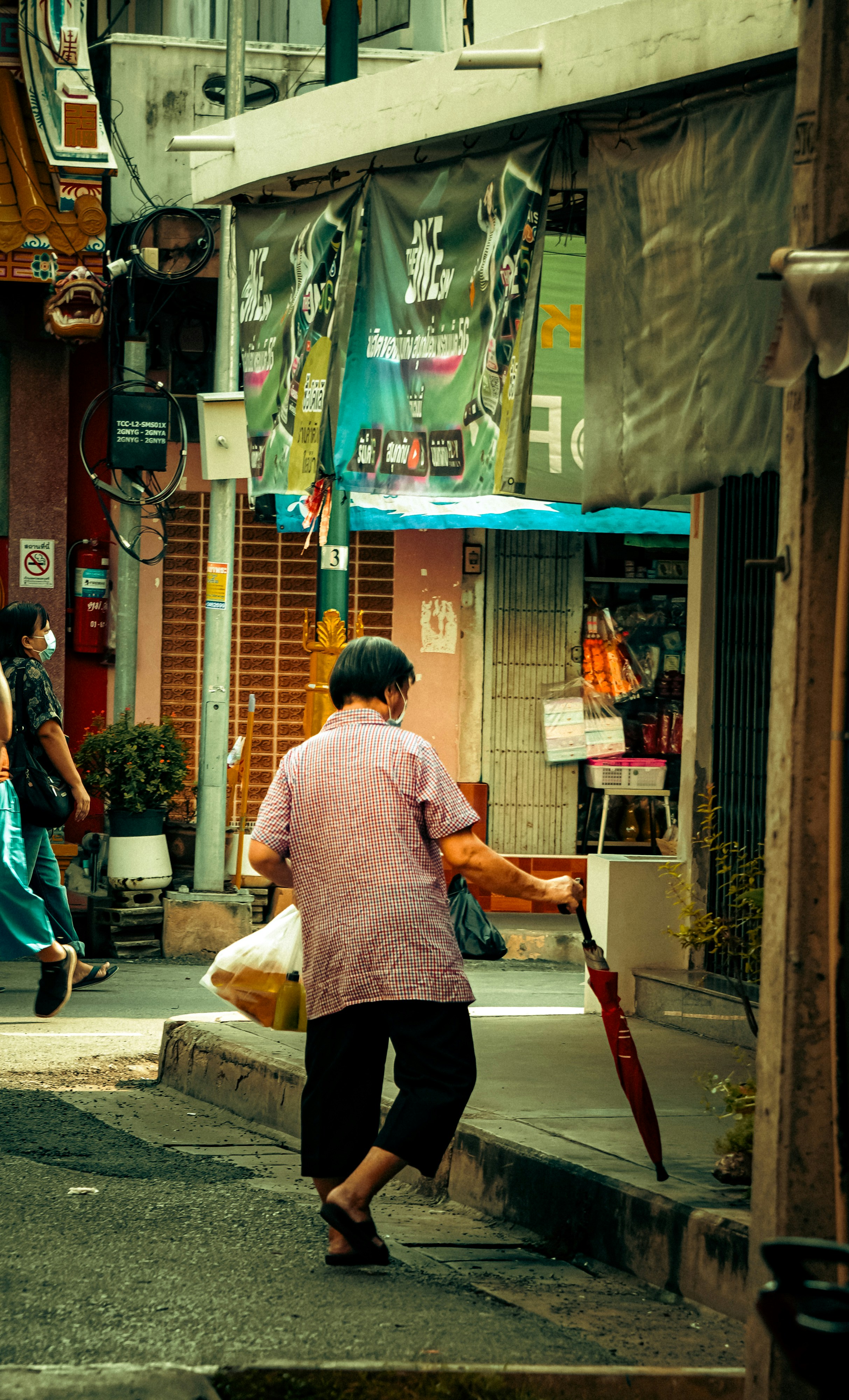 A man walking down a street next to a tall building
