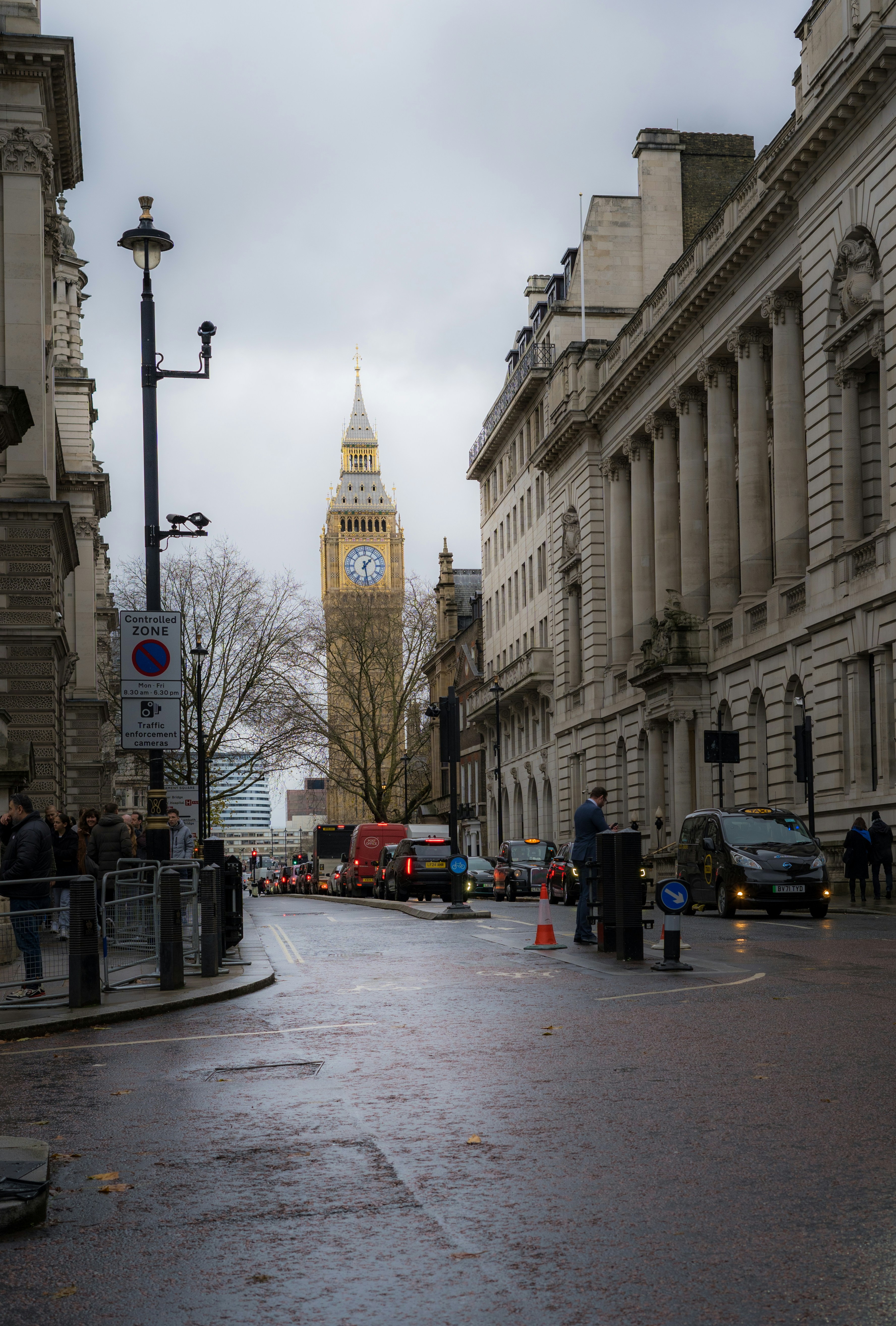 Una strada cittadina con una torre dell'orologio sullo sfondo