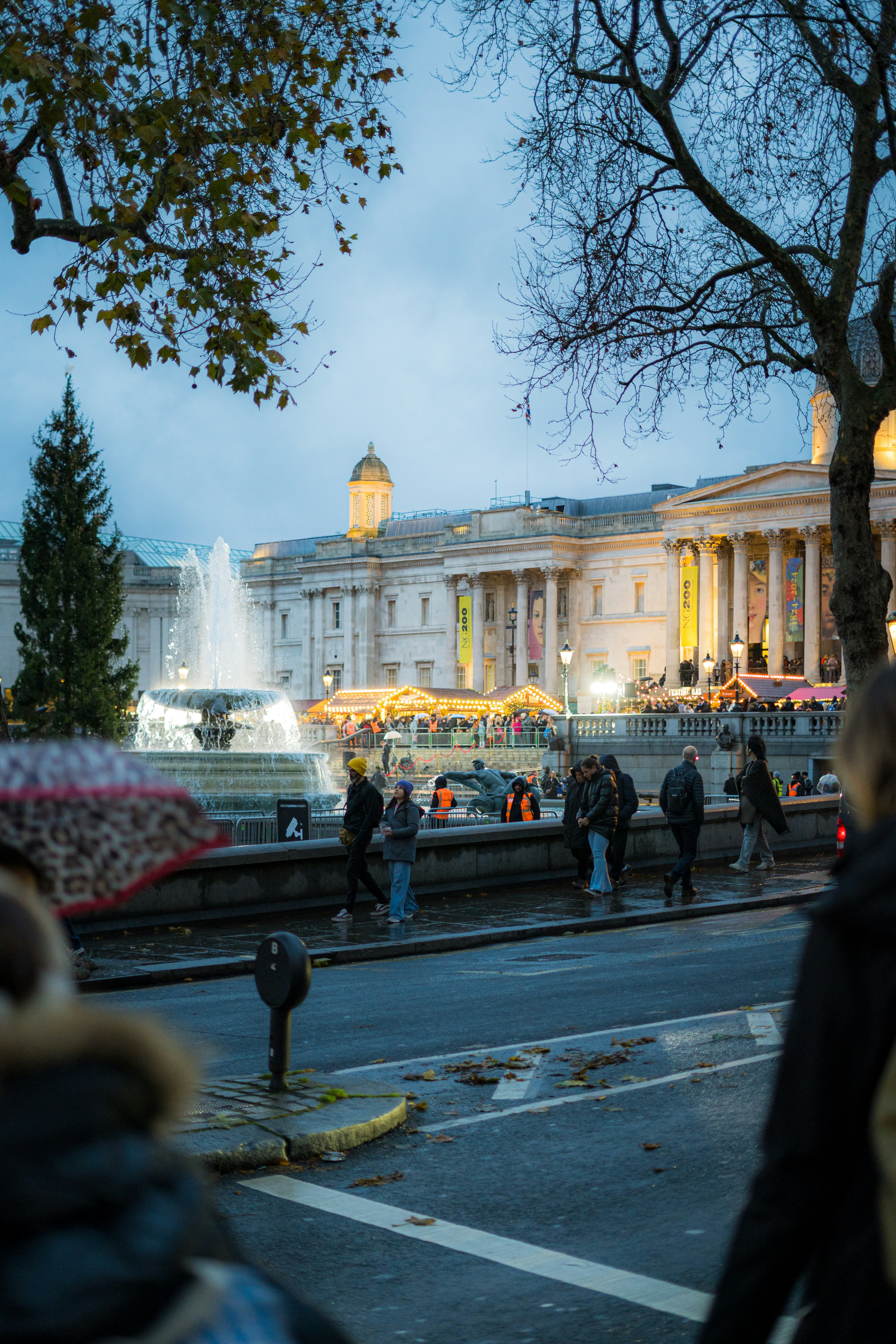 Un gruppo di persone che camminano lungo una strada accanto a una fontana