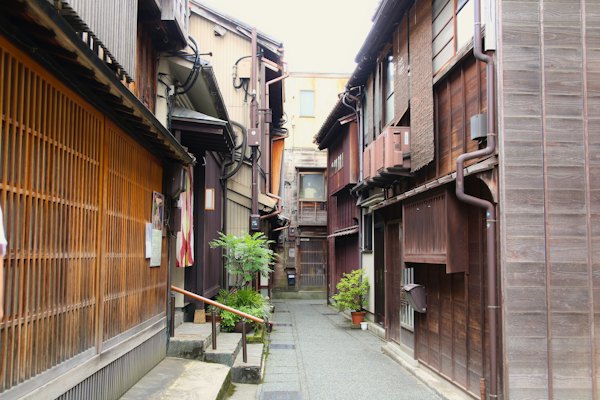 A narrow alley way with wooden buildings on both sides — Kanazawa, Japan