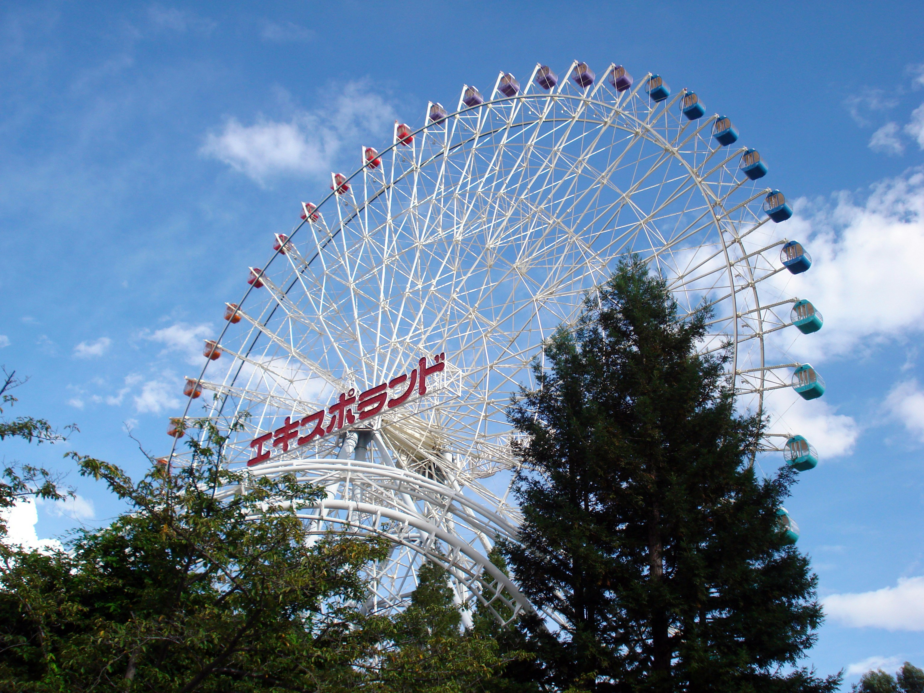 A large ferris wheel sitting next to a forest