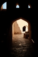 An archway in a building with a light at the end
