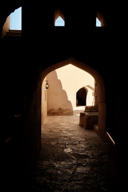 An archway in a building with a light at the end