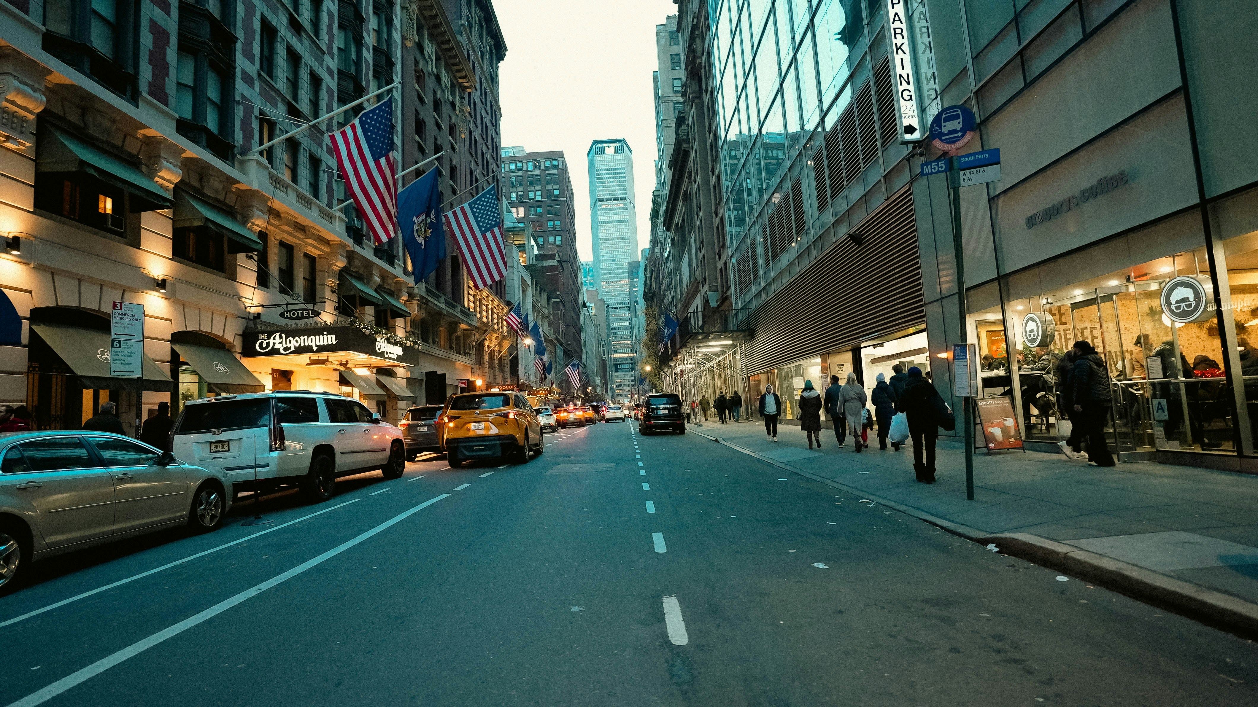 A city street filled with lots of traffic next to tall buildings