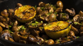 A pan filled with mushrooms and oranges on top of a stove