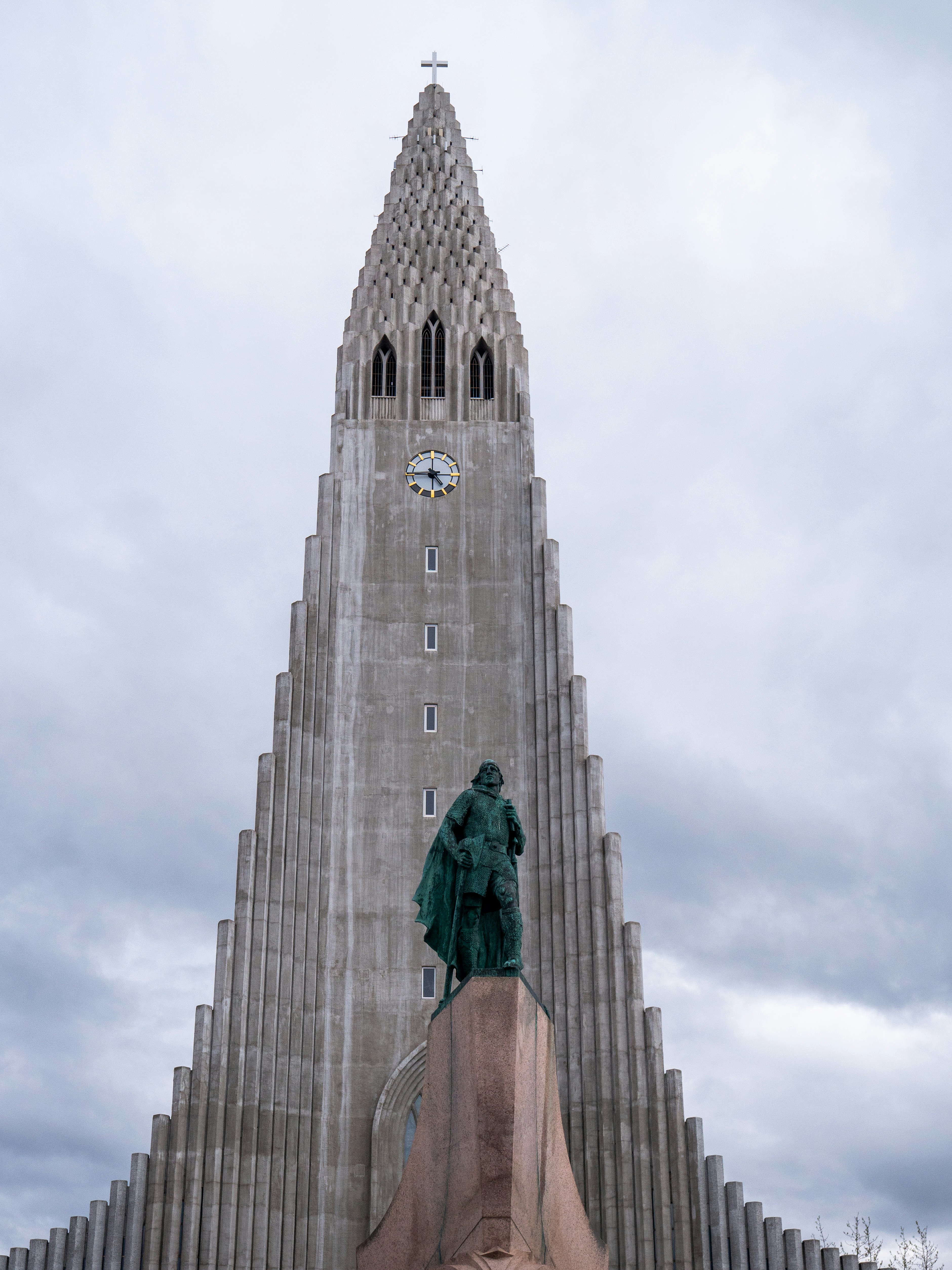 A very tall building with a statue in front of it