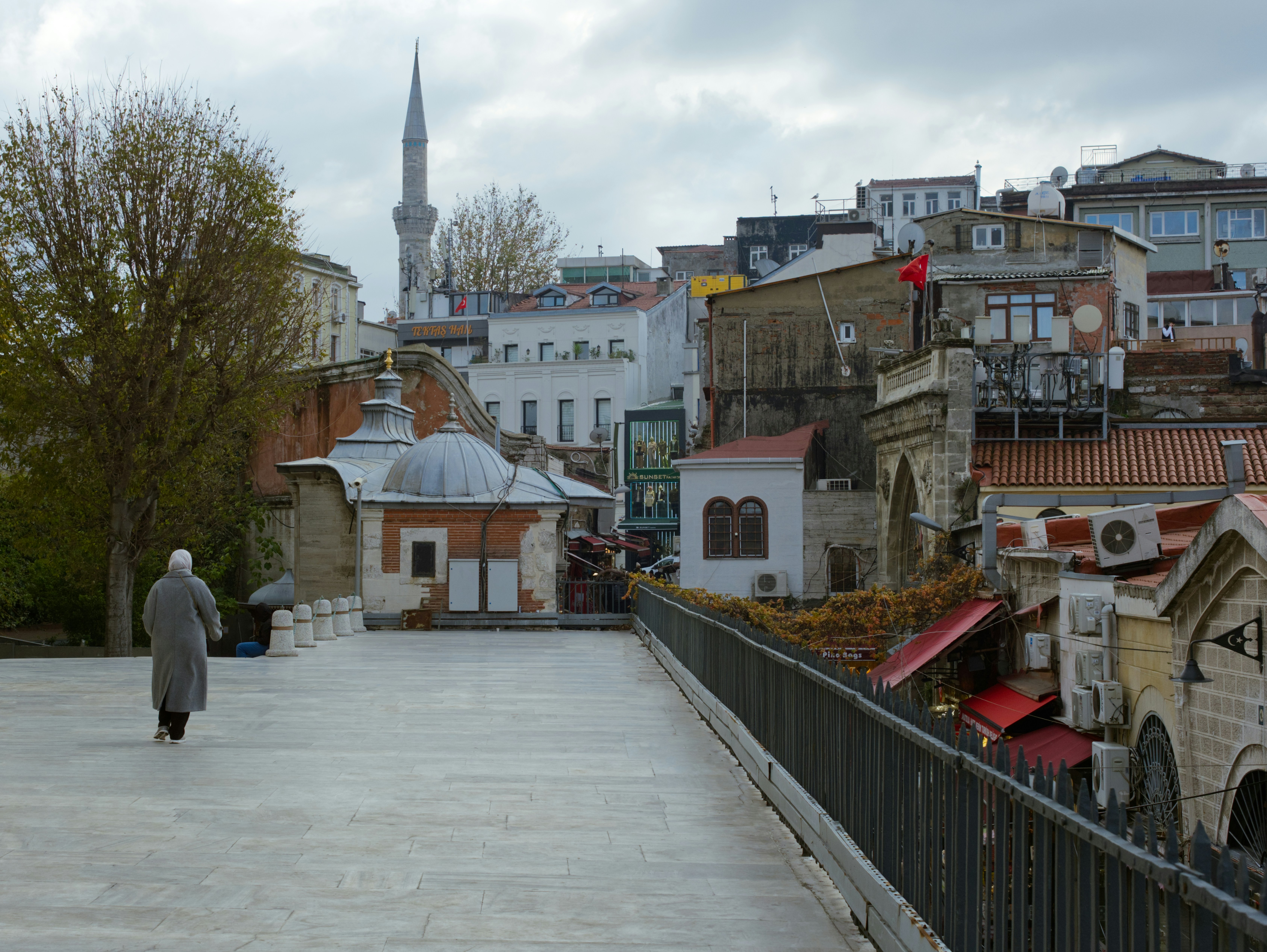 A person walking down a walkway in a city