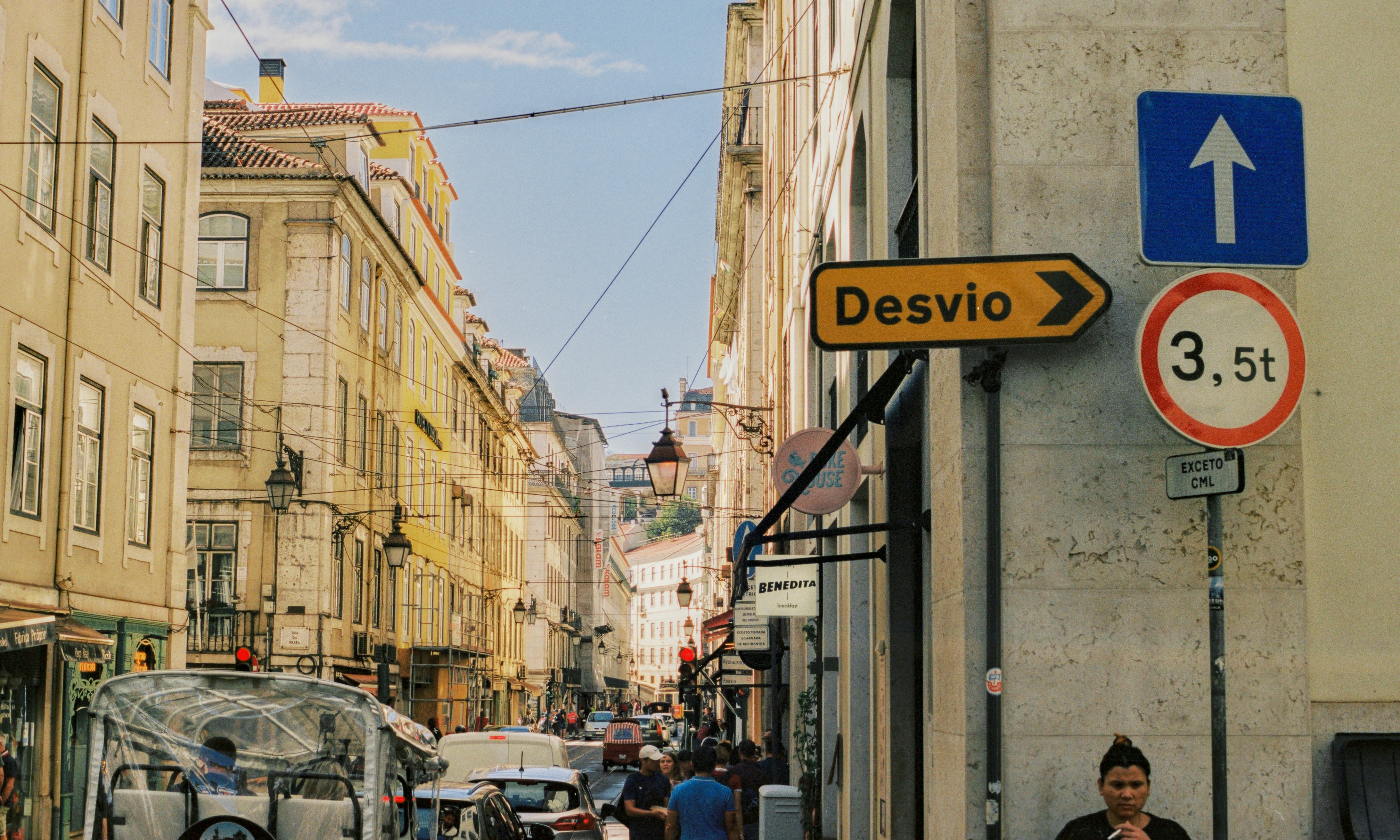 A man walking down a street next to tall buildings