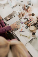 A woman sitting at a table with makeup
