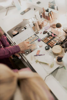 A woman sitting at a table with makeup