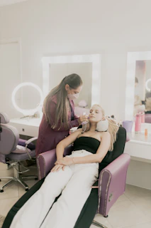 A woman sitting in a chair getting her hair done