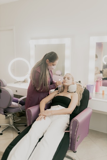 A woman sitting in a chair getting her hair done