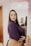 A woman standing in a room with her hands on her hips