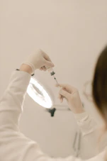 A woman in a white sweater brushing her teeth