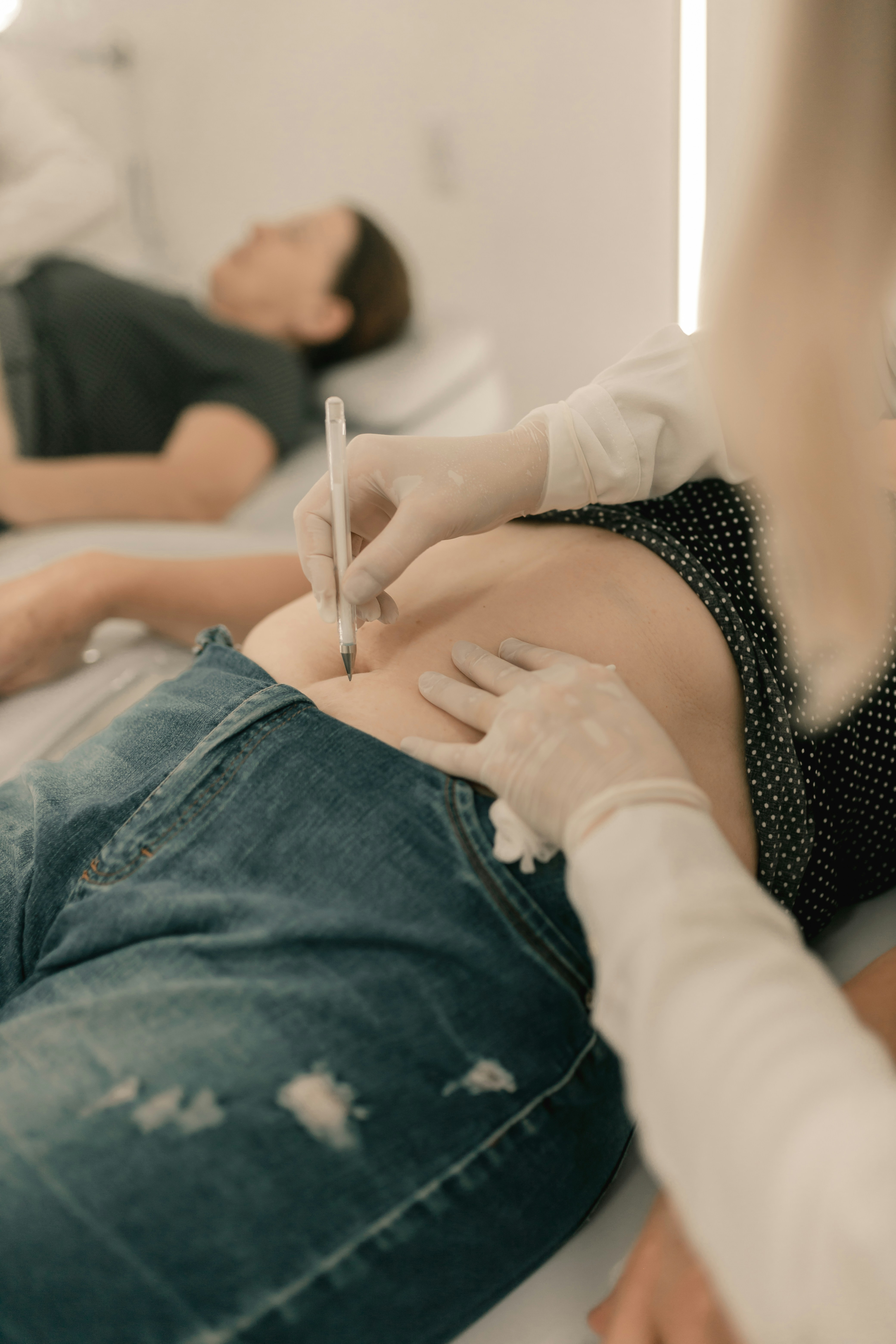 A woman laying on a bed with a person writing on her stomach