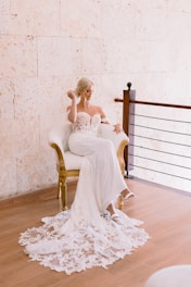A woman in a white dress sitting on a chair