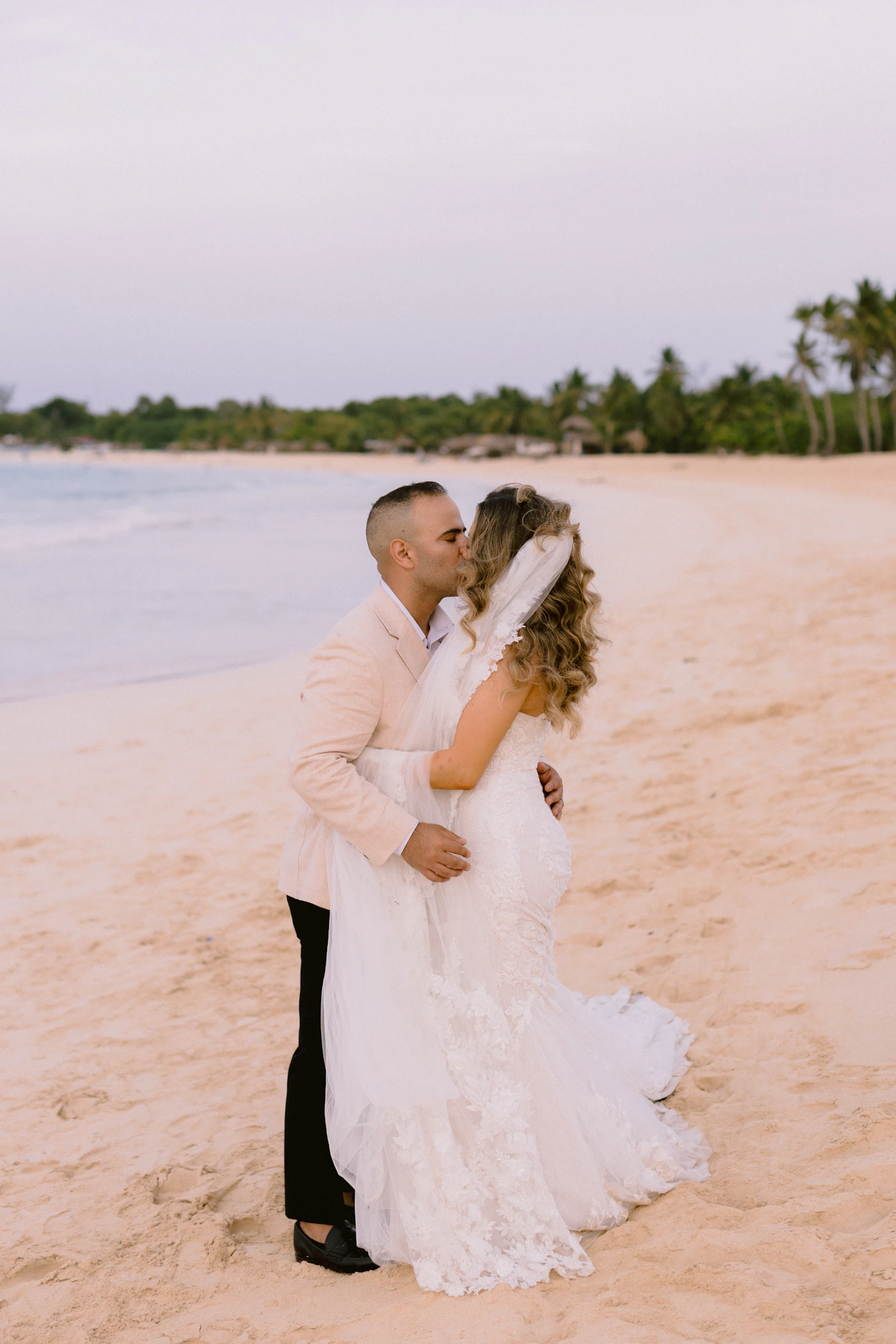 Saving money on wedding photography packages — A bride reviews her wedding album with her partner at home.