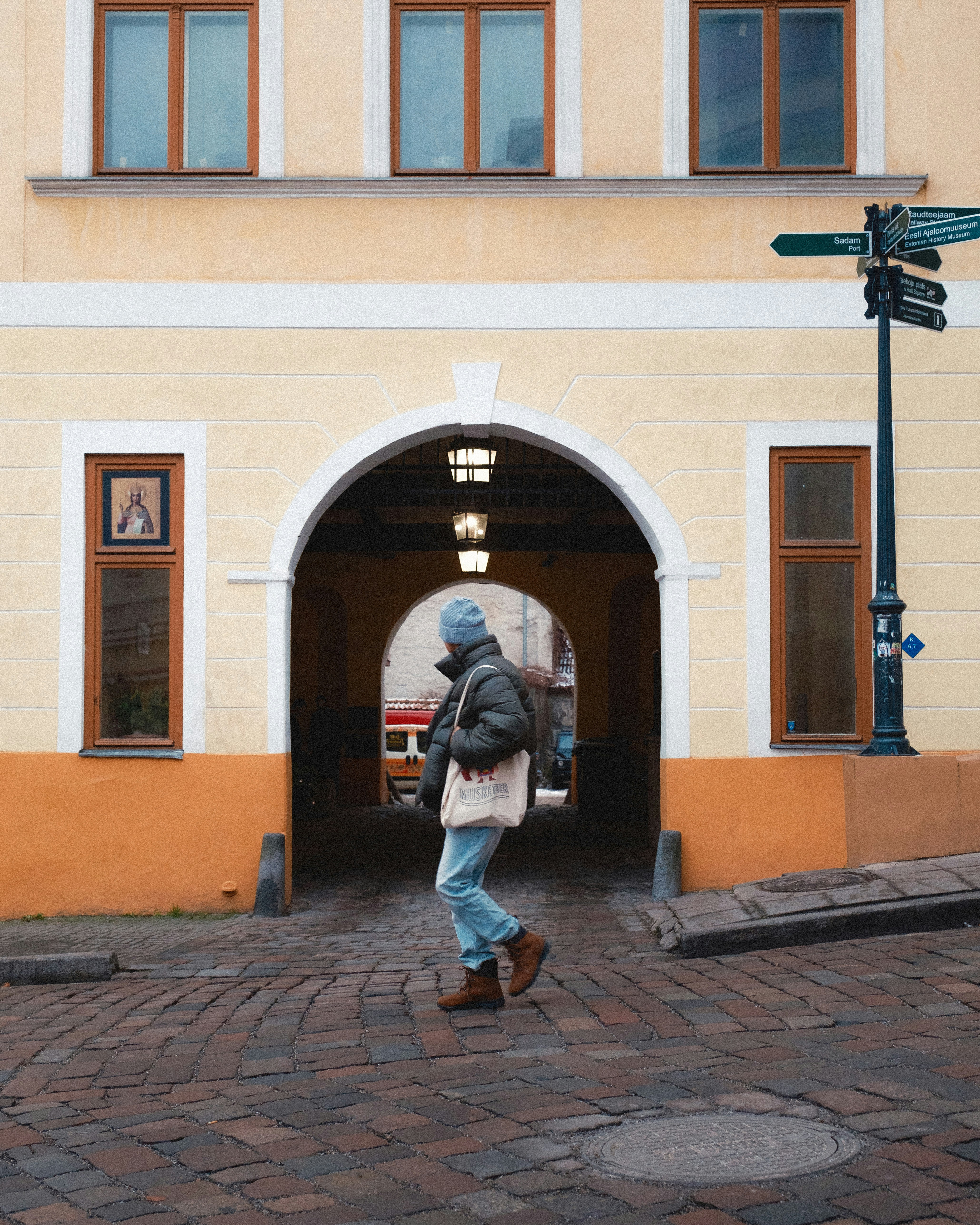 A man walking in front of a yellow building