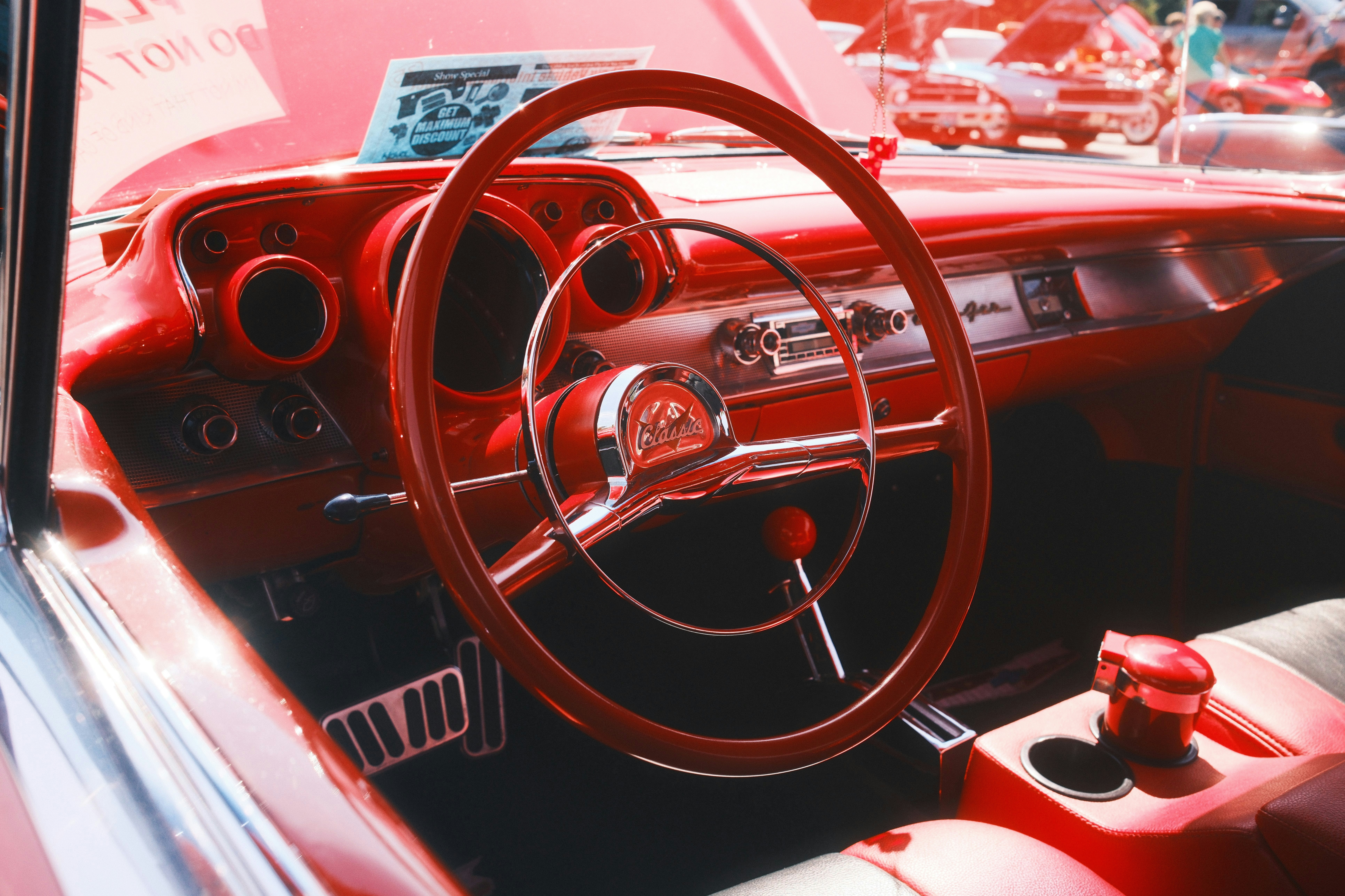 A red car with a steering wheel and dashboard