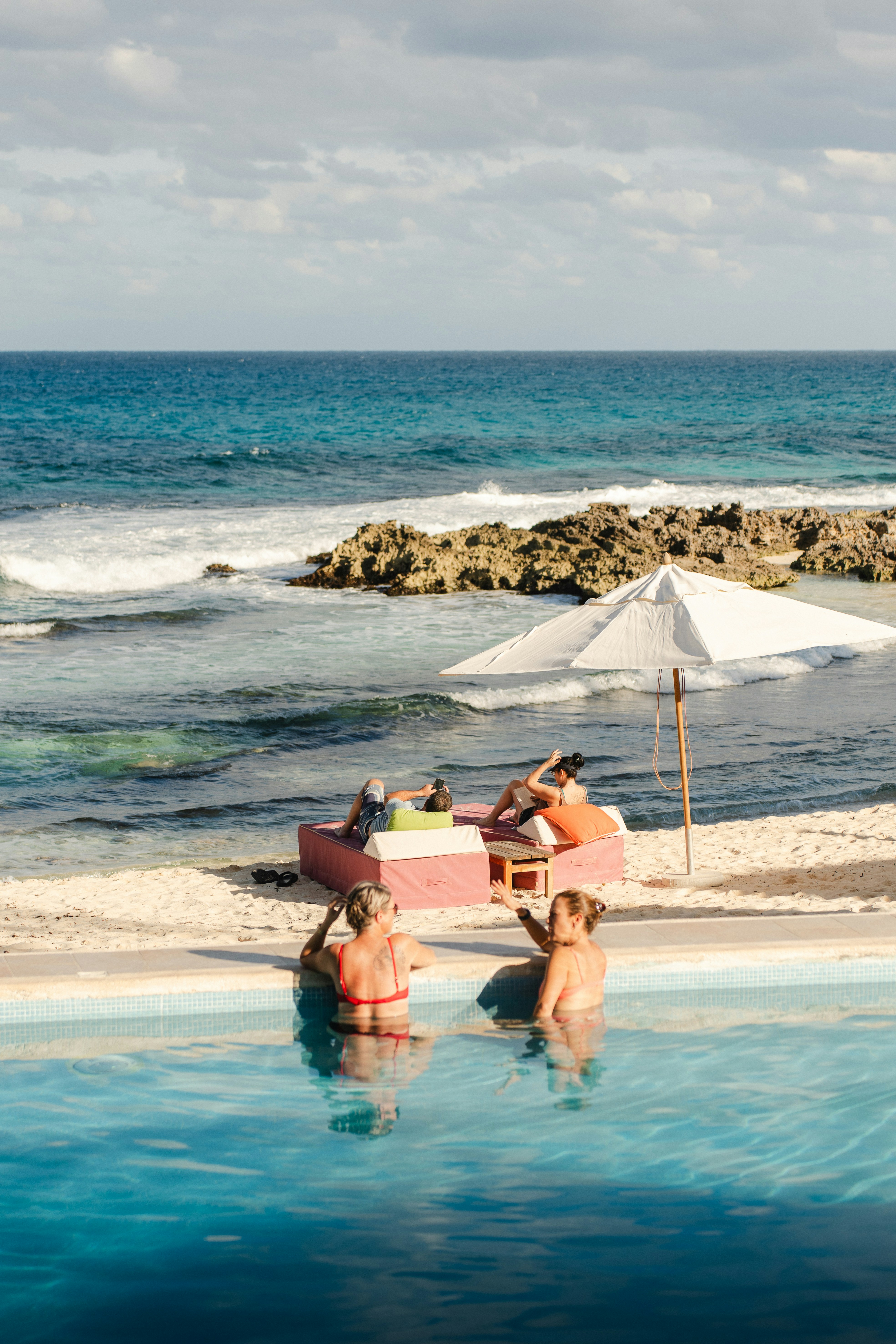 A group of people sitting around a swimming pool