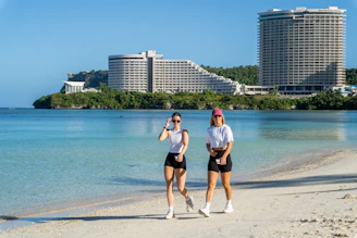 A couple of people that are standing in the sand