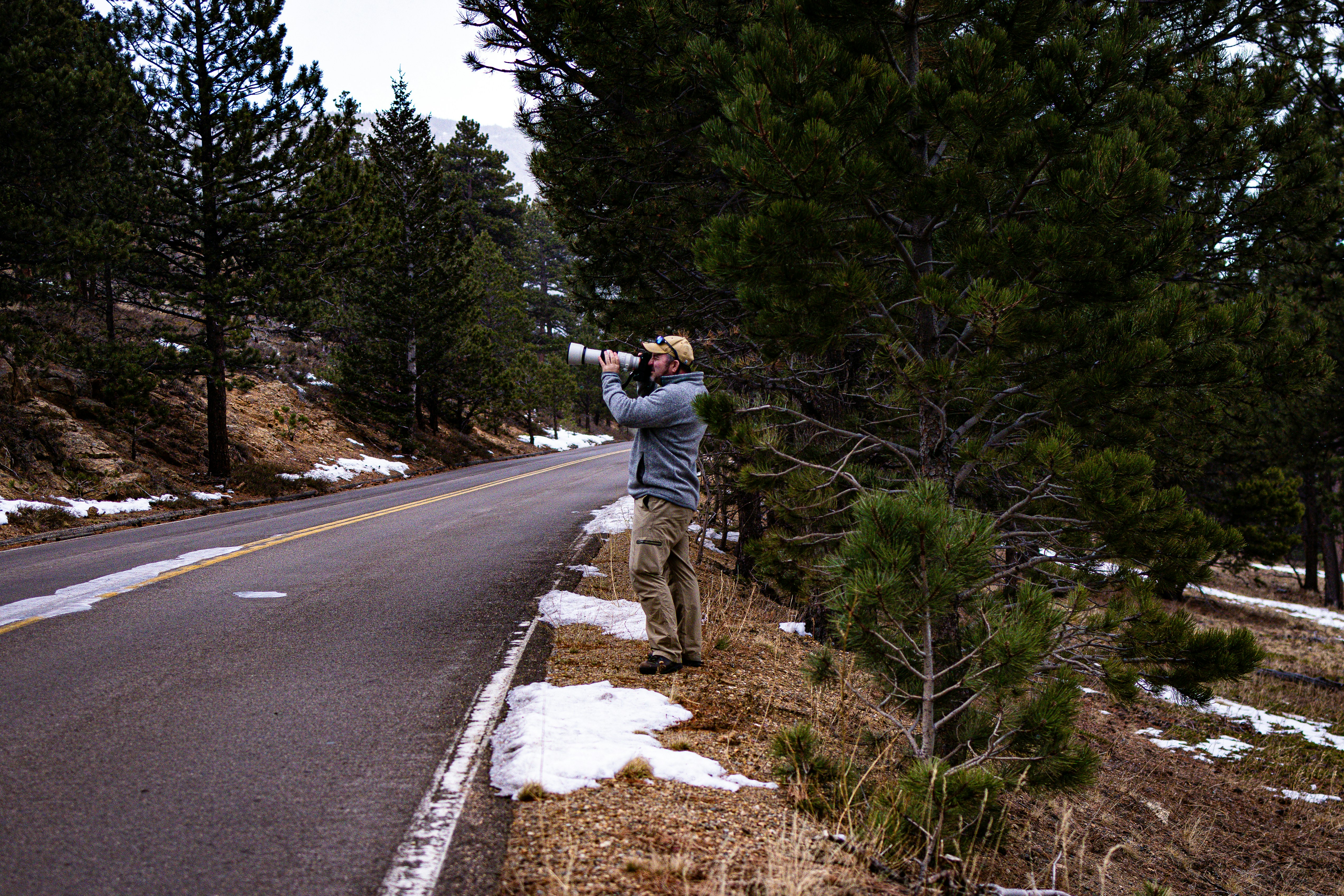 Un hombre tomándose una foto a un lado de la carretera
