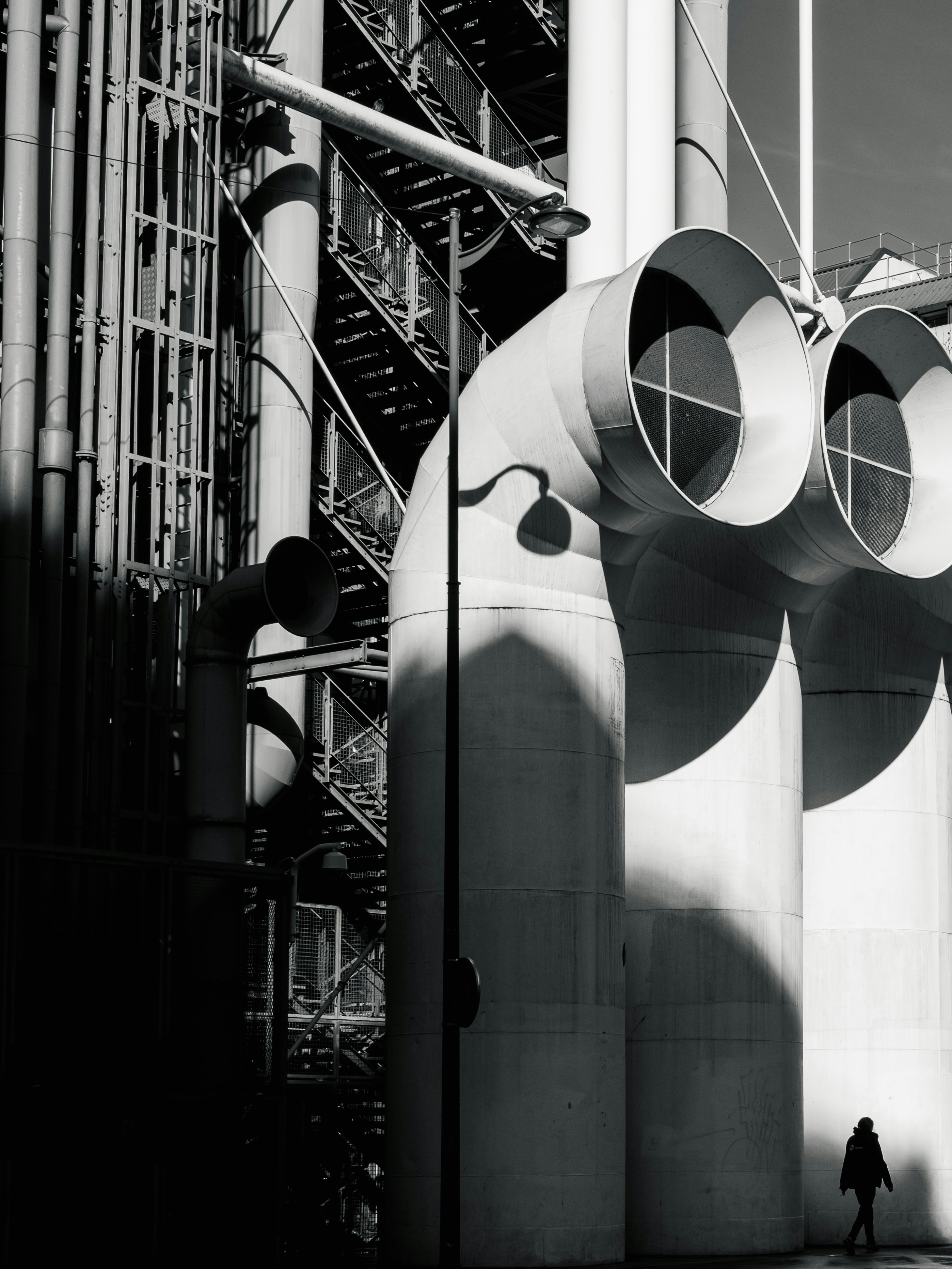 A black and white photo of a person walking past a building