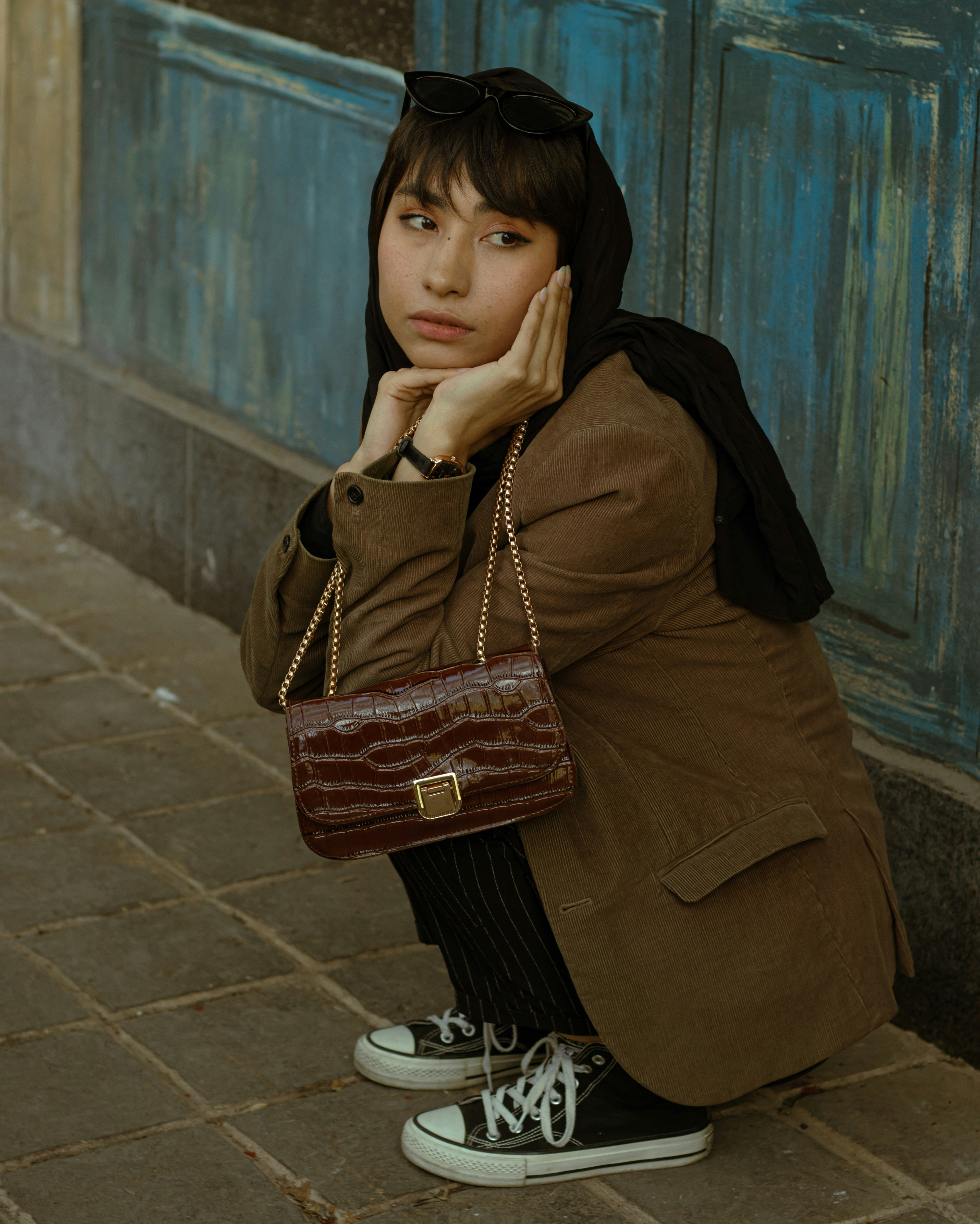 A woman sitting on the ground with a purse