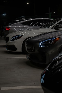 A group of cars parked in a parking lot at night