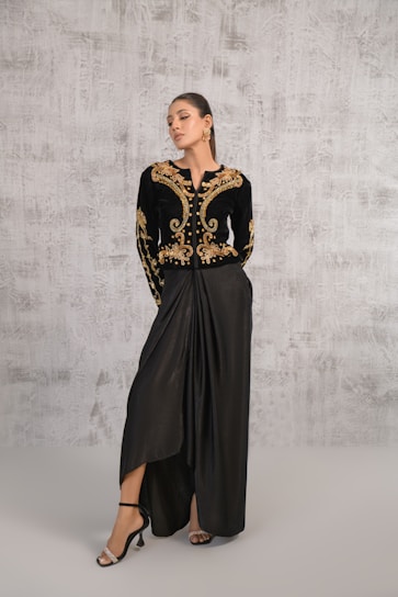 A woman wearing a black and gold dress