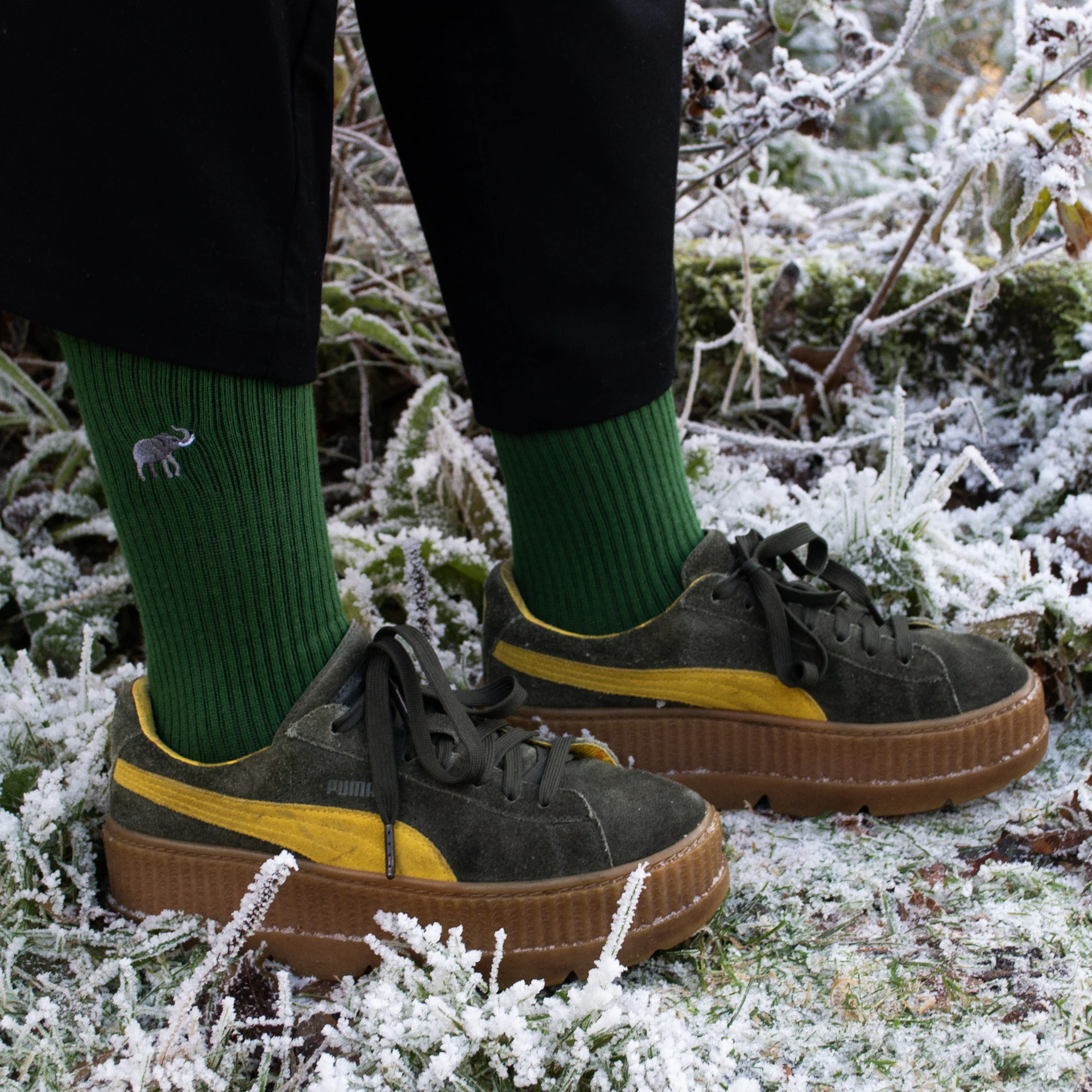 A person wearing green and yellow shoes in the snow
