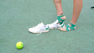 A person standing next to a tennis ball on a court