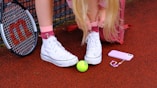 A little girl with a tennis racket and a tennis ball