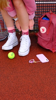 A tennis player is tying her tennis racket