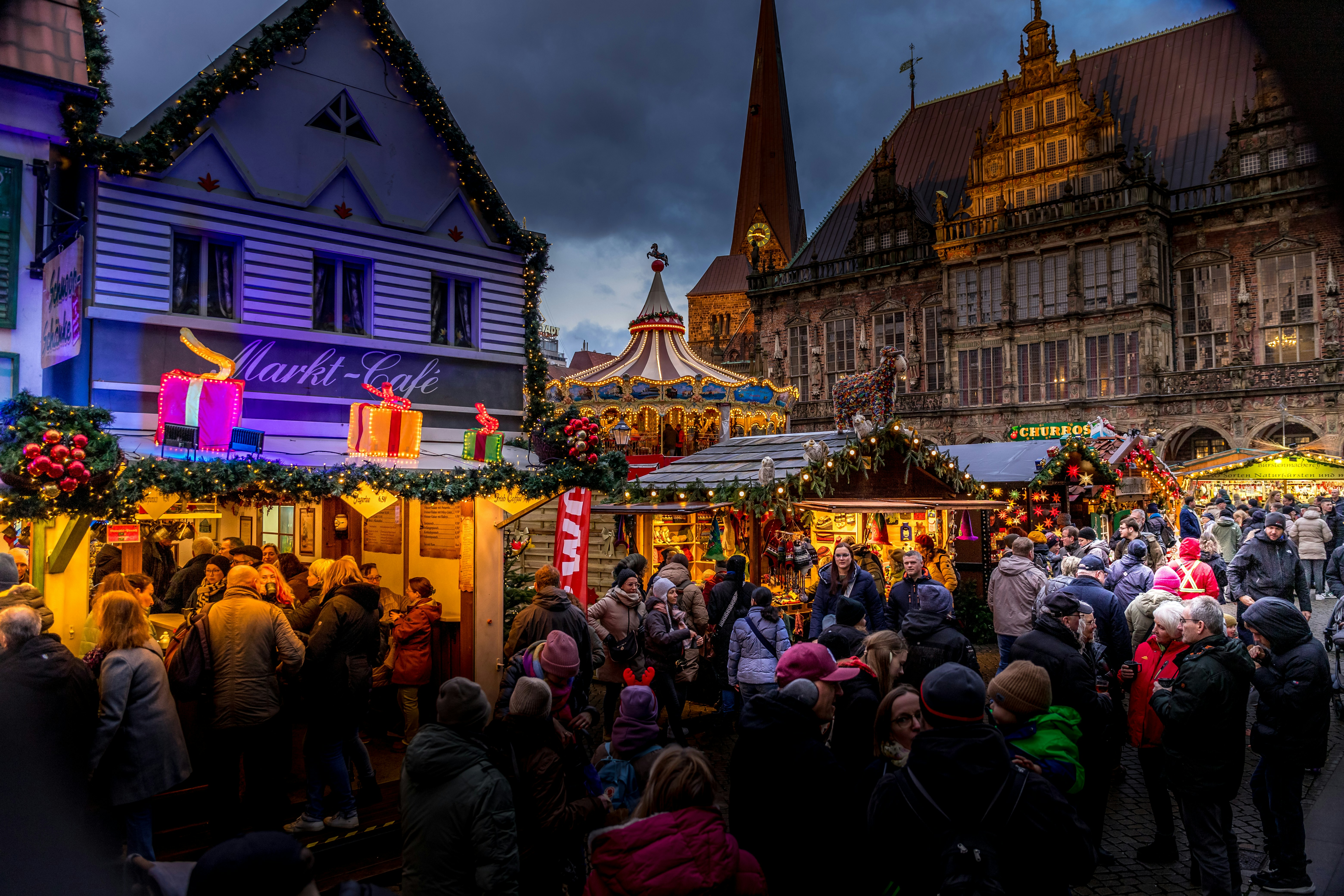 A crowd of people standing around a christmas market