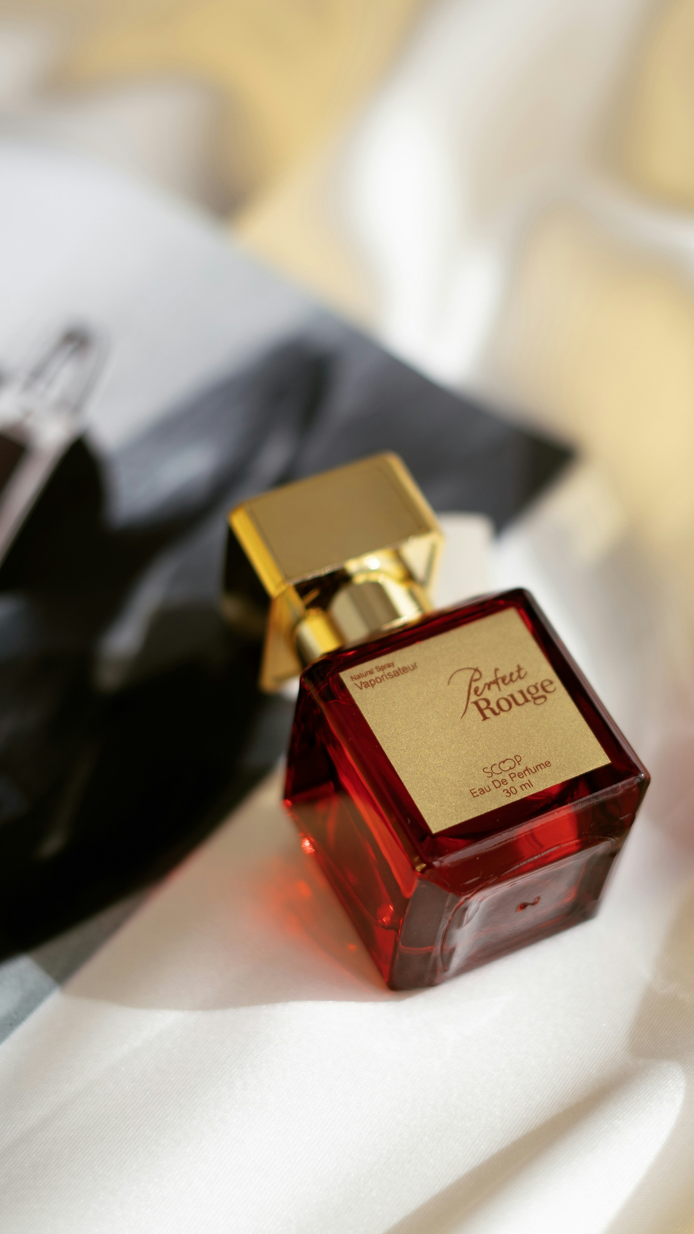 A bottle of perfume sitting on top of a bed