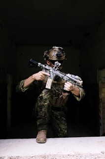 A man in camouflage holding a machine gun