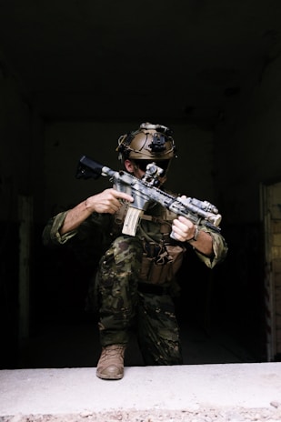 A man in camouflage holding a machine gun