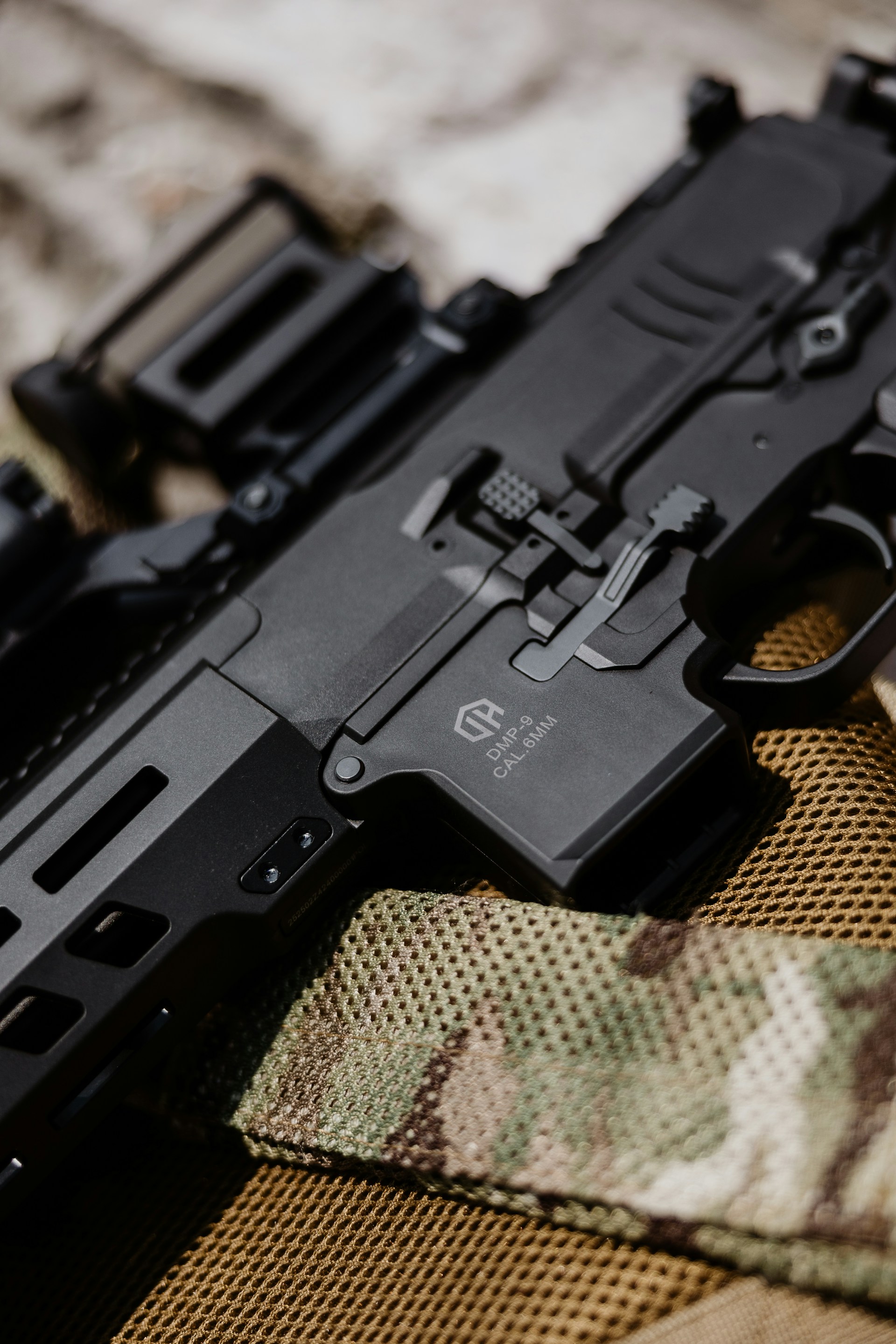 A close up of a gun on a camouflage cloth