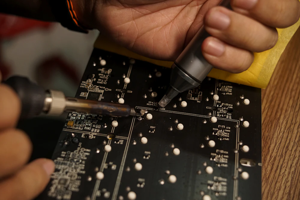Technicien intervenant sur une carte électronique lors d'une formation IPC
