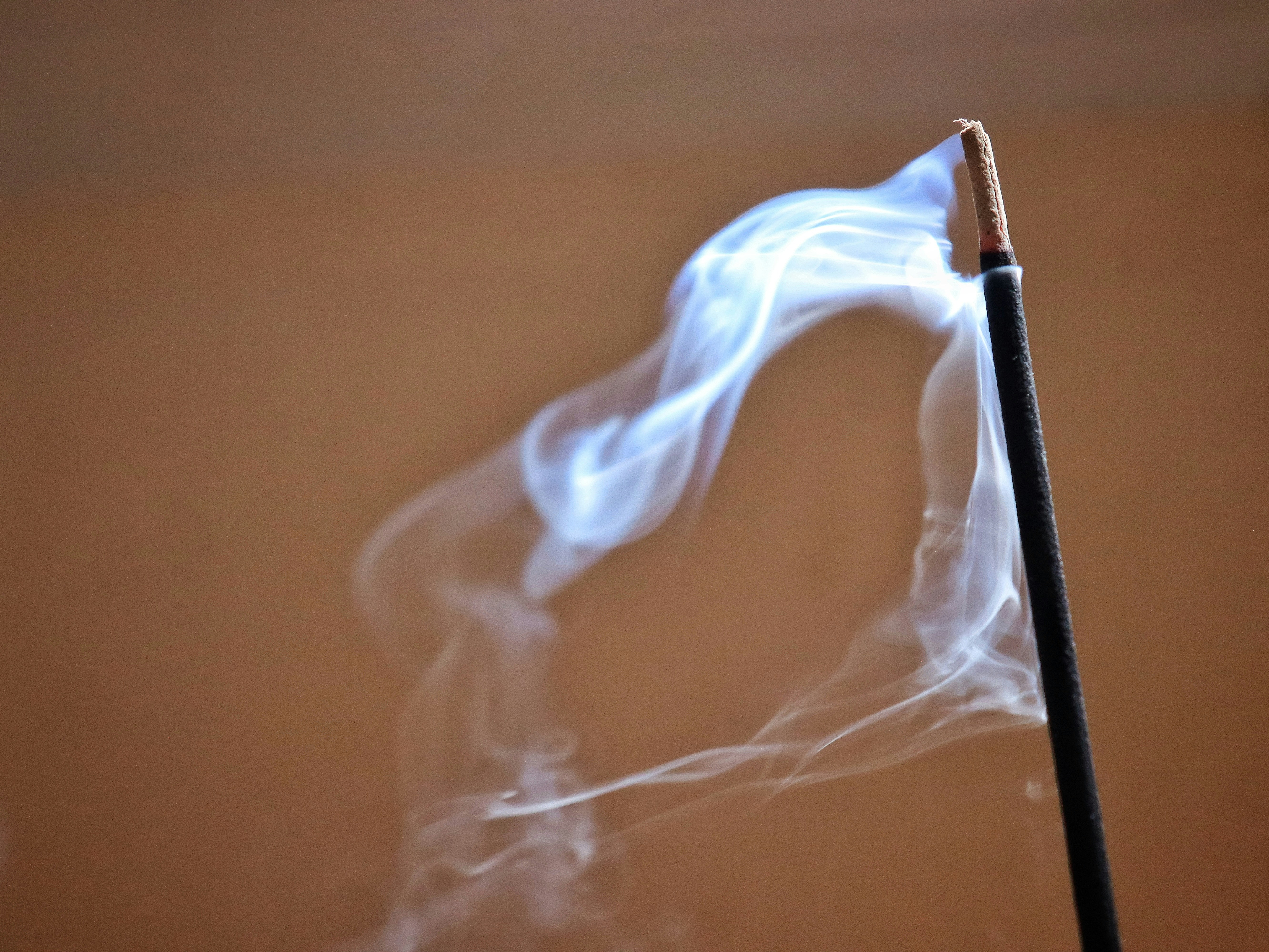 A close up of a matchstick with smoke coming out of it
