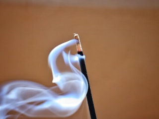 A close up of a matchstick with smoke coming out of it